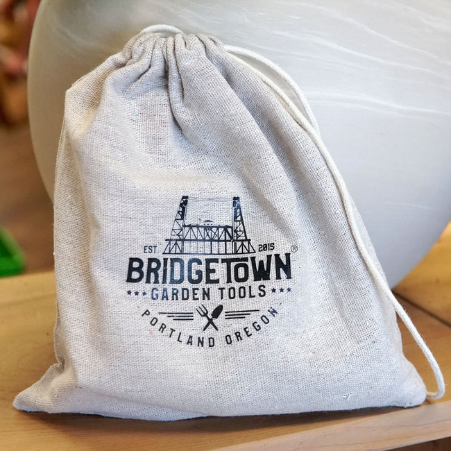 Front view of cotton drawstring storage bag for the tool sharpening kit showing printed logo on natural canvas background