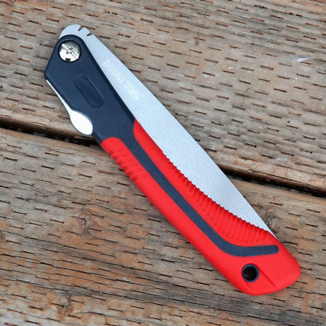 Folding 8" saw with red handle and silver blade on a wooden surface