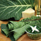 Flash collard greens with a bowl of sautéed greens on a wooden surface