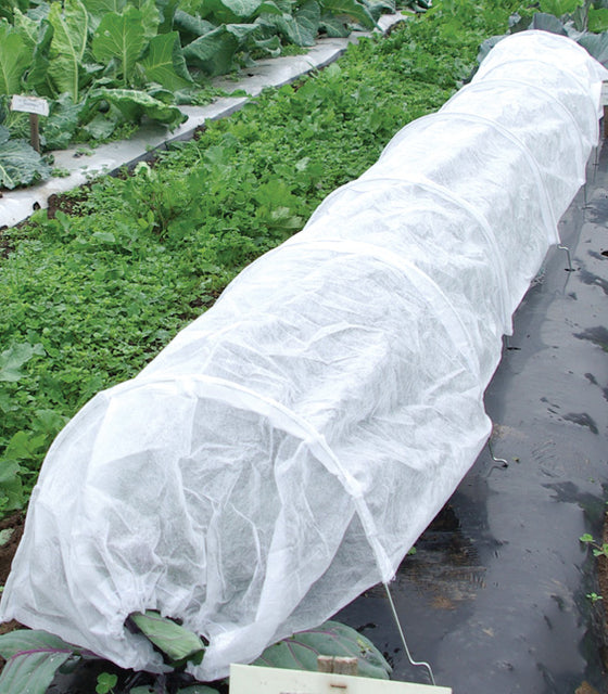 Front view of fleece tunnel row cover showing sewn-in wire hoops forming a low white tunnel over a garden row
